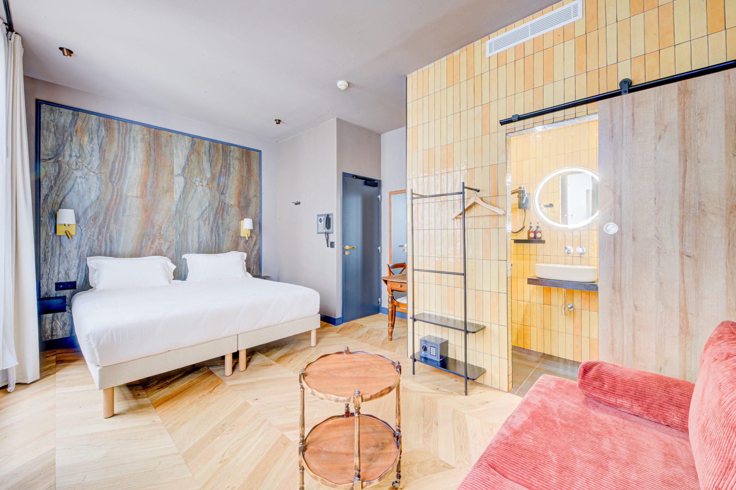 Suite de l’Hôtel Maât Batignolles, mur minéral et parquet à chevrons